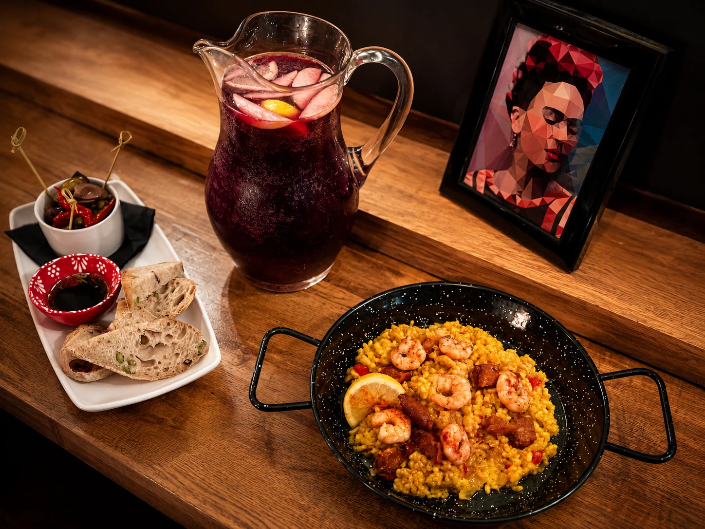 A pan of seafood paella with sangria and Spanish tapas